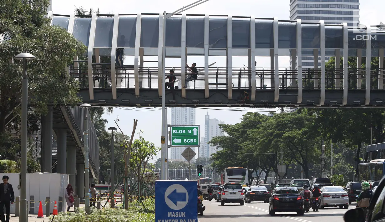 Sejumlah pengendara melintas di bawah JPO Gelora Bung Karno di Jalan Jenderal Sudirman, Jakarta, Jumat (22/2). Ditarget selesai pada Januari 2019, hingga kini proses revitalisasi masih terus berjalan. (Liputan6.com/Helmi Fithriansyah)