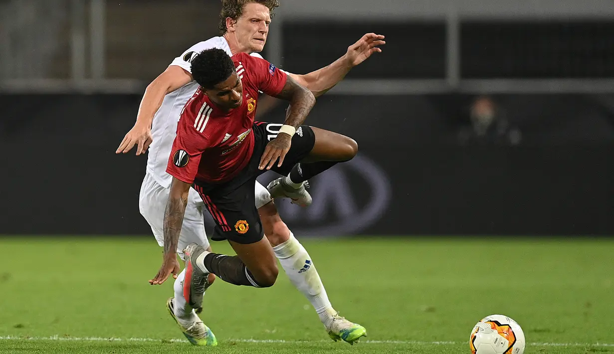 Striker Manchester United, Marcus Rashford, berebut bola dengan gelandang Copenhagen, Jens Stage, pada laga perempat final Liga Europa di RheinEnergie Stadion, Jerman, Selasa (11/8/2020) dini hari WIB. Manchester United menang 1-0 atas Copenhagen. (AFP/Wolfgang Rattay/pool)