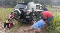 Mobil Rizki yang tersesat di sawah saat dievakuasai warga. (Ahmad Adirin/Liputan6.com)