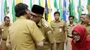 Mendagri, Tjahjo Kumolo (kanan) memberikan selamat kepada Plt Gubernur Aceh Nova Iriansyah usai serah terima surat penugasan Pelaksana Tugas (Plt) Gubernur Aceh dan Bupati Bener Meriah di Kemendagri Jakarta, Senin (9/7). (Liputan6.com/Herman Zakharia)