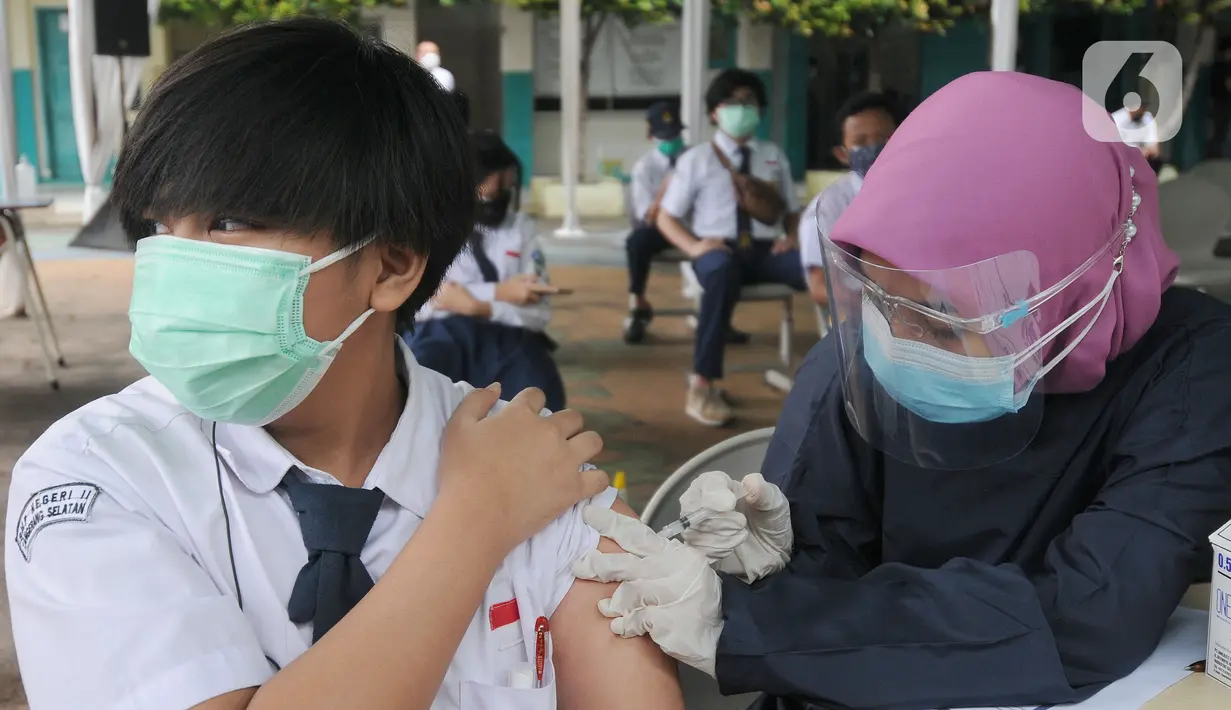 Paramedis memberikan suntikan vaksinasi kepada murid SMP di SMPN 11, Serpong, Tangerang Selatan, Rabu (14/072021). Dinas Kesehatan Tangerang Selatan menggelar vaksinasi COVID-19 perdana, Rabu (14/7/2021) dengan  menargetkan 1.000 pelajar. (merdeka.com/Arie Basuki)