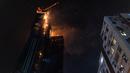 Kebakaran melanda lokasi konstruksi di Hong Kong, Jumat (3/3/2023). Kebakaran melanda lantai atas gedung pencakar langit yang sedang dibangun di daerah Tsim Sha Tsui, Hong Kong, dini hari waktu setempat. (AP Photo/Louise Delmotte)