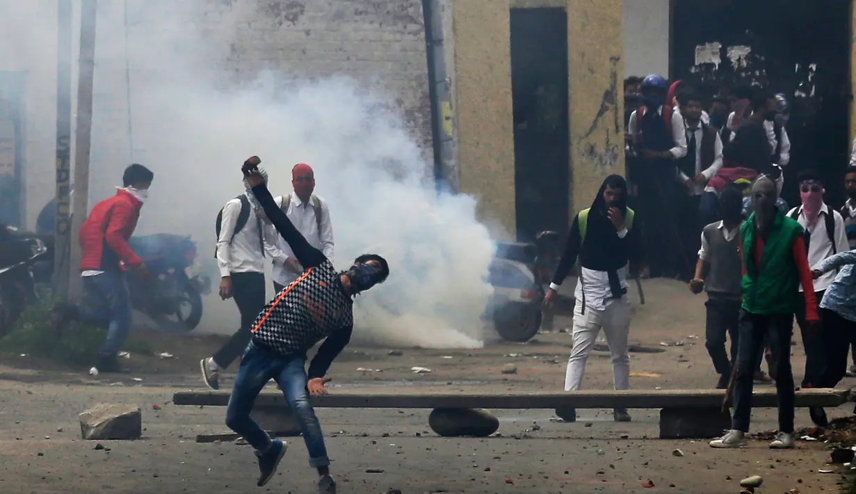 Pelajar Kashmir melempari seorang polisi India saat bentrok di Srinagar, Kashmir, Rabu (17/5). Beberapa bulan belakangan ini keadaan di Kashmir terus diwarnai oleh bentrok antara pelajar dengan polisi. (AP Photo / Mukhtar Khan)