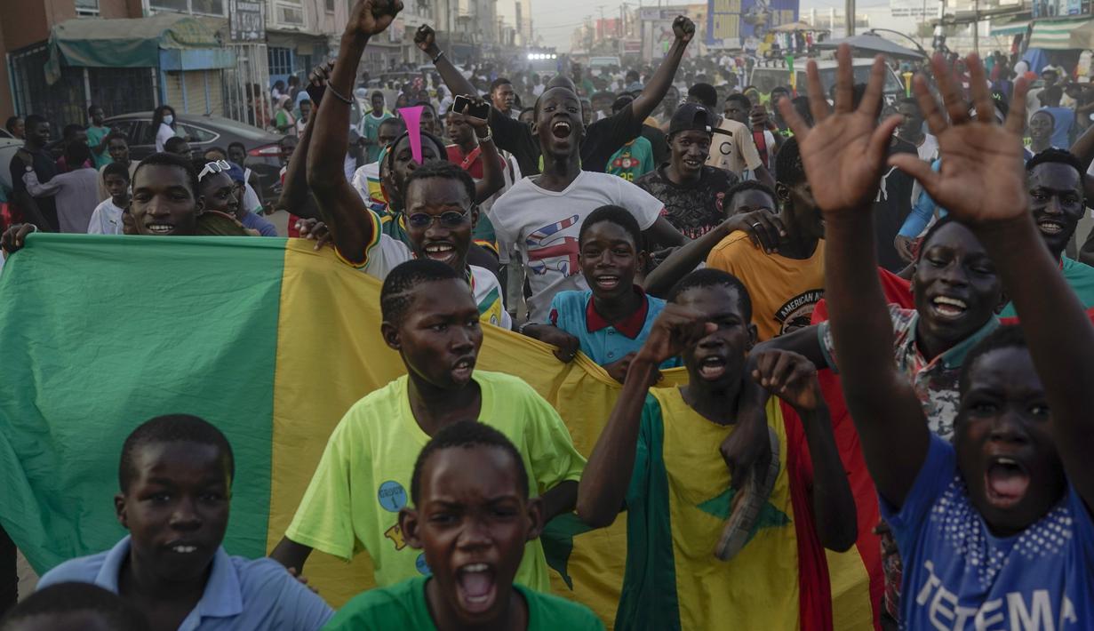 Penggemar klub sepak bola Senegal merayakan kemenangan tim mereka saat melawan Ekuador di laga grup A Piala Dunia 2022 di Qatar, pada layar video yang dipasang di zona penggemar, Dakar, Senegal, Selasa (29/11/2022). Gol pertama dicetak oleh Ismaila Sarr lewat tendangan penaltinya di menit ke-44. (AP Photo/Leo Correa)