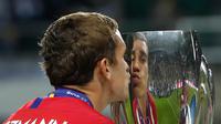 Gelandang Atletico Madrid, Antoine Griezmann mencium Piala Super Eropa usai pertandingan melewan Real Madrid di Lillekula Stadium, Tallinn, Estonia, (15/8). Atletico Madrid berhasil mengalahkan Real Madrid dengan skor telak 4-2. (AP Photo/Pavel Golovkin)