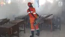 Petugas melakukan pengasapan (fogging) di sebuah sekolah di kawasan Kebon Baru, Tebet, Jakarta, Kamis (28/2). Pengasapan dilakukan terkait adanya warga di kawasan tersebut yang terkena penyakit demam berdarah. (Liputan6.com/Immanuel Antonius)