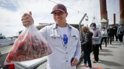 Seorang pria membawa sekantong udang spot segar yang dia beli di Steveston Fisherman's Wharf di Richmond, British Columbia, Kanada (5/6/2020). Musim udang spot tahun ini tertunda akibat kurangnya pasar selama pandemi COVID-19. (Xinhua/Liang Sen)