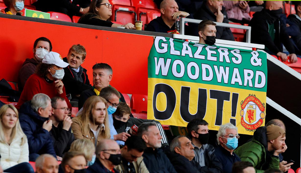 Poster berisi kecaman kepada keluarga Glazers dipasang oleh fans di area tempat duduk penonton dalam laga lanjutan Liga Inggris 2020/2021 pekan ke-37 antara Manchester United melawan Fulham di Old Trafford, Rabu (18/5/2021). Manchester United bermain imbang 1-1 dengan Fulham. (AFP/Phil Noble/Pool)