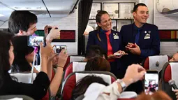 Pasangan Paula Podest dan Carlos Ciuffardi menunjukkan cincin kawinnya usai dinikahkan Paus Fransiskus di atas pesawat selama penerbangan (18/1). Paus Fransiskus melangsungkan upacara pernikahan mereka. (AFP Photo/Vincenzo Pinto)