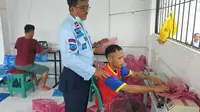 Kepala Lapas Pekanbaru melihat seorang warga binaan tengah membuat jas hujan. (Liputan6.com/M Syukur)
