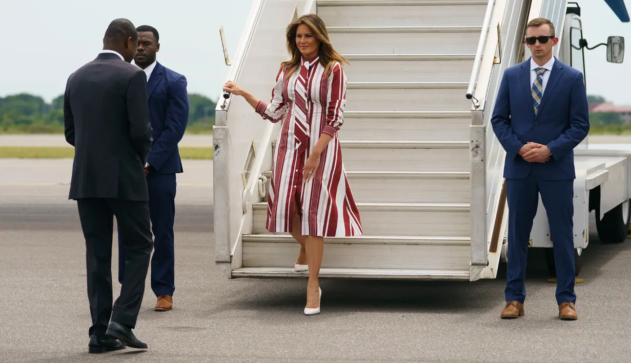 Ibu Negara Amerika Serikat, Melania Trump setibanya di Bandara Internasional Kotoka di Accra, Ghana, Selasa (2/10). Penampilan modis Melania Trump dipadukan dengan heel putih dari Manolo Blahnik seharga sekitar Rp 9 juta. (AP/Carolyn Kaster)