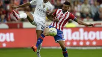 Danilo coba hadang striker Sporting Gijon, Miguel Guerrero (MIGUEL RIOPA / AFP)