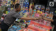 Pedagang melayani pembeli kembang api di Pasar Asemka, Jakarta, Selasa (26/12/2023). (merdeka.com/Imam Buhori)