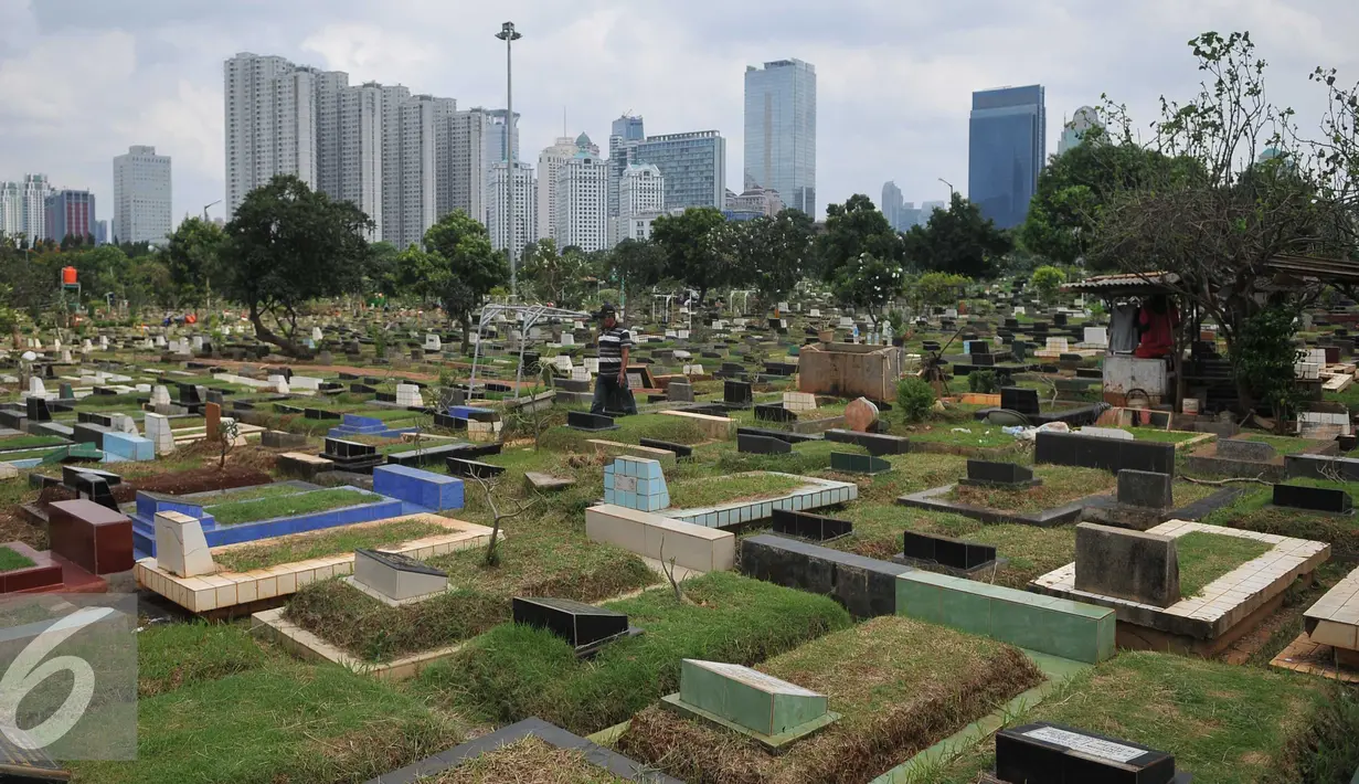 Warga melewati area makam TPU Karet Bivak, Jakarta (2/2). Dinas Pertamanan dan Pemakaman DKI telah menerapkan sistem online dalam pelayanan pemakaman di Ibukota dengan alamat situs pertamananpemakaman.jakarta.go.id. (Liputan6.com/Gempur M Surya)