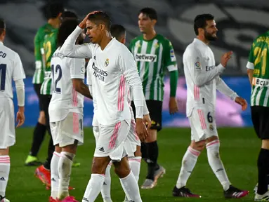 Ekspresi kecewa bek Real Madrid, Raphael Varane (tengah) usai ditahan imbang 0-0 Real Betis dalam laga lanjutan Liga Spanyol 2020/2021 pekan ke-33 di Alfredo Di Stefano Stadium, Madrid, Sabtu (24/4/2021). (AFP/Gabriel Bouys)