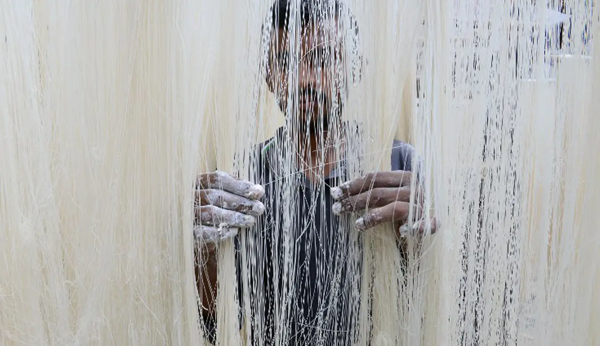 Seorang pekerja menjemur Seviiyan (sejenis bihun) saat proses pembuatan Sheerkhorma di Hyderabad, India. 23 Juni 2015. Sheerkhorma merupakan hidangan manis tradisional khas Ramadan bagi muslim India. (AFP PHOTO/NOAH Seelam)