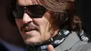 Aktor Johnny Depp memakai kacamata hitam dan syal saat menghadiri sidang pencemaran nama baik di Pengadilan Tinggi, London, Inggris, Selasa (21/7/2020). Johnny Depp menggugat tabloid The Sun atas artikel yang menyebut dirinya telah melakukan kekerasan terhadap sang istri. (AP Photo/Frank Augstein)