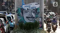 Pengendara melintas di sisi mural bergambar aktivis HAM, Munir di Jalan Ciledug Raya, Jakarta, Senin (7/9/2020). Munir Said Thalib seorang aktivis HAM Indonesia meninggal dunia setelah diracun dalam penerbangan menuju Amsterdam, Belanda pada 7 September 2004. (Liputan6.com/Helmi Fithriansyah)