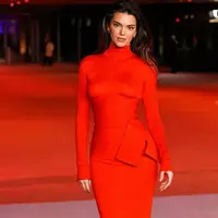 Ia memadukannya dengan korset pita diikat rapi di bagian samping. Serta rok panjangnya warna merah. [@kendalljenner]