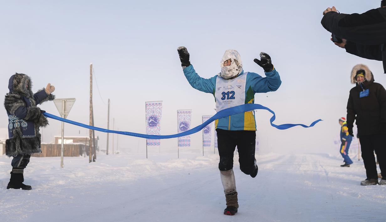 Seorang pelari melewati garis finis dalam ajang maraton terdingin di dunia internasional pada suhu minus 53 derajat (-63,4 Fahrenheit) di dekat Oymyakon, republik Sakha, juga dikenal sebagai Yakutia, Timur Jauh Rusia, Sabtu, 22 Januari 2022. (AP/Ivan Nikiforov)