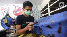Perajin menyelesaikan proses pembuatan batik di  Batik Tradisiku, Bogor, Jawa Barat, Kamis (6/8/2020). Perajin batik mitra binaan Pertamina ini berinovasi dengan membuat motif dan warna baru untuk mengatasi anjloknya penjualan batik sebagai dampak ekonomi wabah corona. (merdeka.com/Arie Basuki)