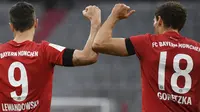 Pemain Bayern Munchen, Robert Lewandowski dan Leon Goretzka melakukan selebrasi usai membobol gawang Eintracht Frankfurt pada laga Bundesliga di Allianz Arena, Minggu (24/5/2020). Bayern Munchen menang 5-2 atas Eintracht Frankfurt. (AP/Andreas Gebert)