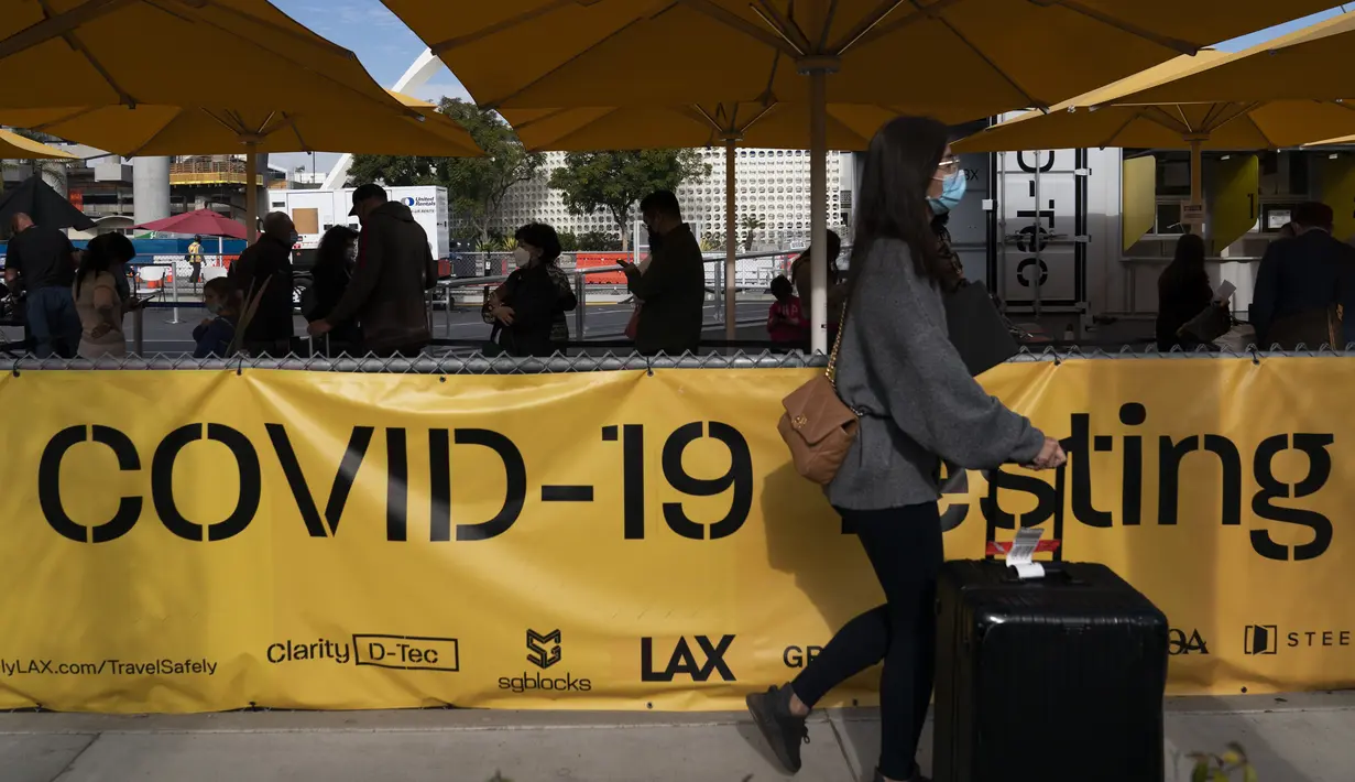 Pelancong mengantre untuk dites COVID-19 di Bandara Internasional Los Angeles di Los Angeles, Senin (20/12/2021). Departemen Kesehatan Masyarakat Los Angeles County melaporkan jumlah kasus baru harian COVID-19 meningkat tiga kali lipat selama seminggu. (AP Photo/Jae C.Hong)
