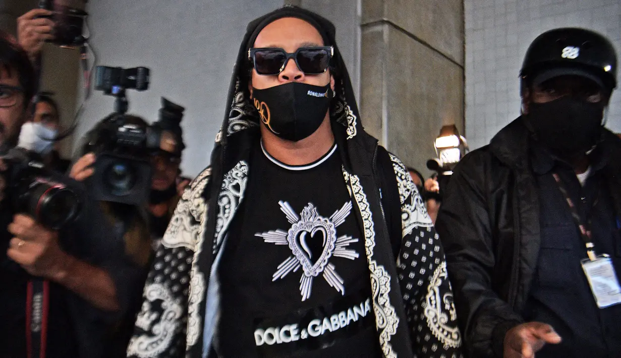Mantan pemain timnas Brasil, Ronaldinho tiba di bandara El Galeao di Rio de Janeiro, setelah menjalani tahanan rumah di Paraguay, Selasa (25/8/2020). Ronaldinho menghirup udara bebas setelah lima bulan menjadi tahanan rumah karena memasuki Paraguay dengan paspor palsu. (Carl DE SOUZA/AFP)