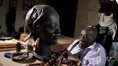 Edward Njenga bekerja memperbaiki patung karyanya yang berjuluk 'Women's Guild Member (2008)' di bengkelnya, Nairobi, Kenya, Senin (12/3). Njenga adalah salah satu pematung terkemuka asal Afrika Timur.  (AFP PHOTO/Yasuyoshi CHIBA)