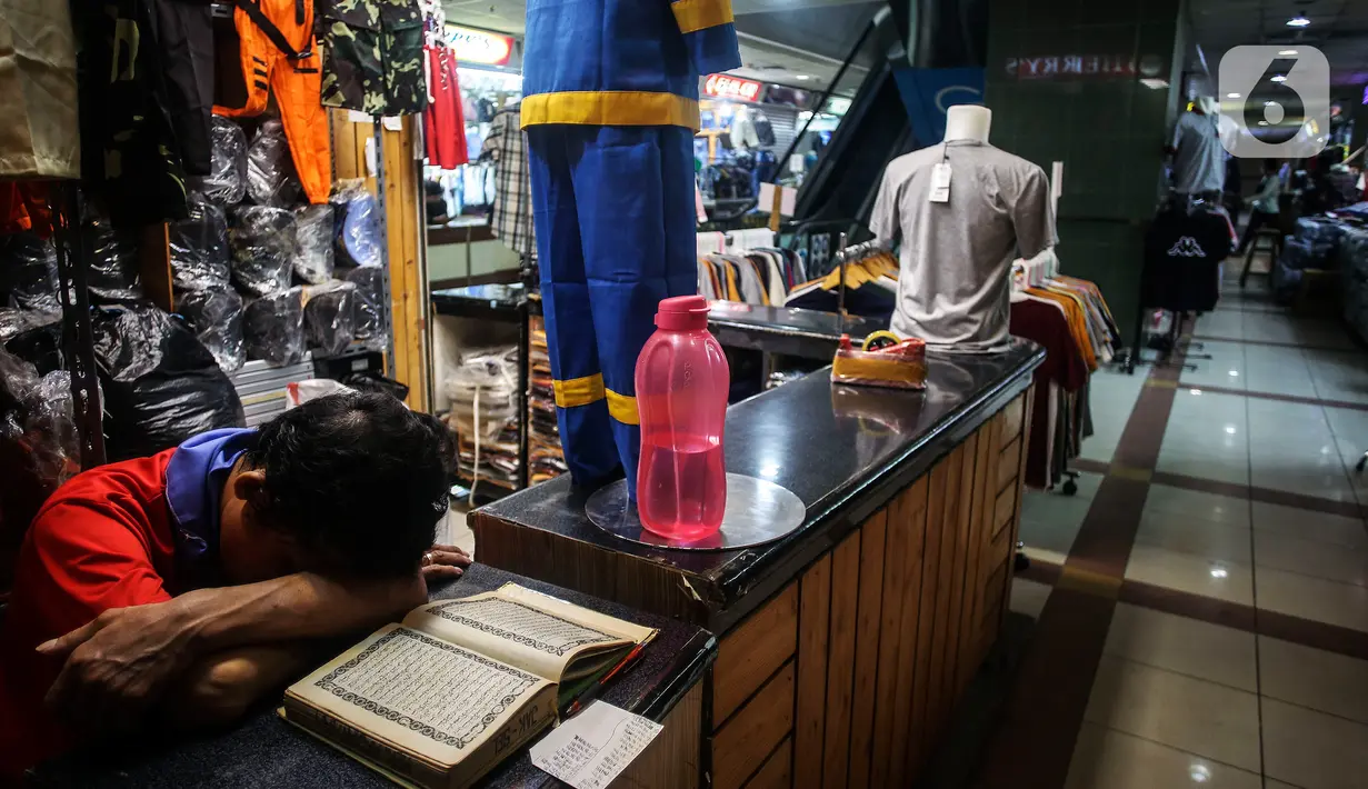 Pedagang tertidur di antara barang dagangannya di Pasar Tanah Abang, Jakarta, Selasa (27/7/2021). Pasar Tanah Abang yang kembali dibuka mulai Senin (26/7) mewajibkan pengunjung serta pedagang menunjukkan sertifikat vaksinasi COVID-19 untuk masuk ke pasar. (Liputan6.com/Johan Tallo)