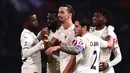 Penyerang AC Milan, Zlatan Ibrahimovic (tengah) berselebrasi bersama rekan setimnya  usai mencetak gol ke gawang Bologna pada pertandingan lanjutan Liga Serie A Italia di stadion Renato Dall'Ara di Bologna, Italia, Minggu (24/10/2021). AC Milan menang atas Bologna 4-2. (AFP/Marco Bertorello)