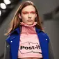Model mengenakan crop top label Fyodor Golan edisi Fall/Winter 2017 dengan logo Post-it selama London Fashion Week di London, 17 Februari 2017. Label Inggris itu menunjukkan busana yang unik dan inspirasinya datang dari meja kerja. (NIKLAS HALLE'N/AFP)