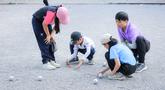 Beberapa anak memainkan olahraga Petanque di Lapangan Latih Dua Kompleks 700th Anniversary of Chiang Mai Stadium, Thailand, Kamis (11/12/2025). Petanque merupakan salah satu olahraga favorit bagi masyarakat Thailand. (Bola.com/Bagaskara Lazuardi)