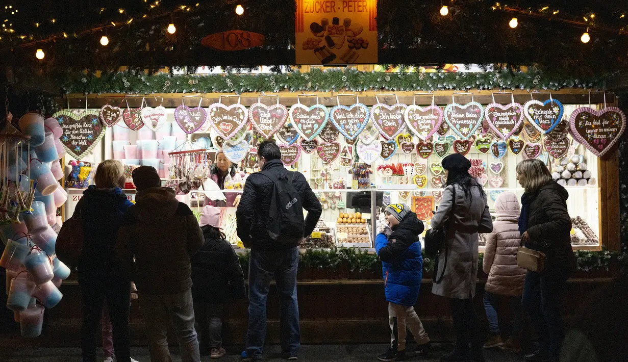 Seorang penjual menjual roti jahe dan permen lainnya di pasar Natal di depan balai kota Wina di Wina, Austria (19/11/2019). Christkindlmarkt atau Pasar Natal bertebaran di Kota Vienna. Setiap distrik, ataupun spot-spot wisata memiliki Pasar Natal masing-masing. (AFP Photo/Joe Klamar)