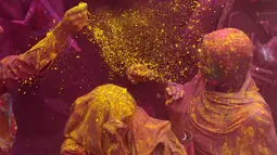 Janda India menaburkan bubuk berwarna-warni saat mengikuti perayaan Holi di kota Vrindavan, India, (9/3). Holi dirayakan di negara India, Nepal, Bangladesh, dan negara dengan pemeluk agama Hindu. (AFP Photo / Dominique Faget)