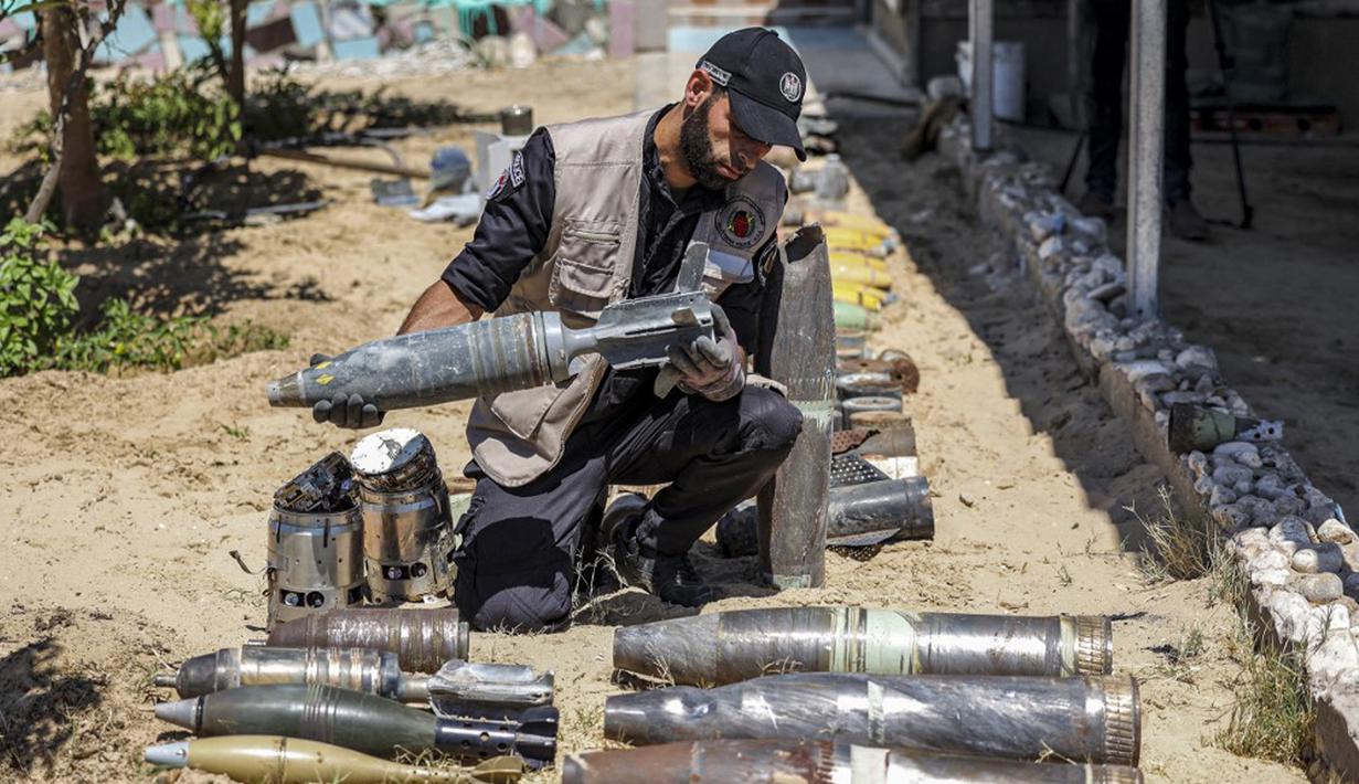 Seorang ahli bahan peledak Hamas menunjukkan proyektil yang tidak meledak setelah konflik Mei 2021 dengan Israel di kantor polisi setempat di Khan Yunis, Jalur Gaza, Sabtu (5/6/2021). Perang 11 hari antara Hamas dan Israel menewaskan 254 orang Palestina dan 12 orang Israel. (MAHMUD HAMS/AFP)