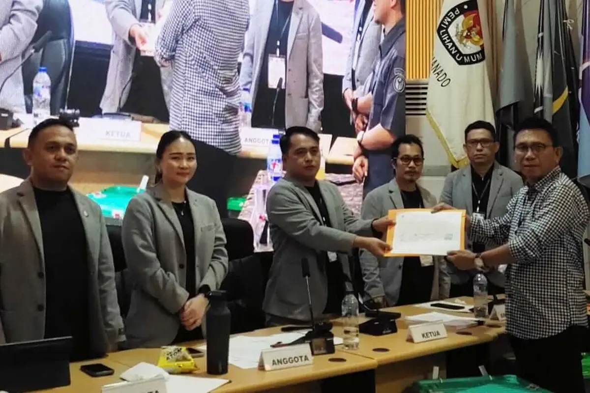 Ketua KPU Manado Ferley B Kaparang menyerahkan hasil pleno kepada perwakilan pasangan Andrei Angouw - Richard Sualang pada, Senin (2/12/2024).