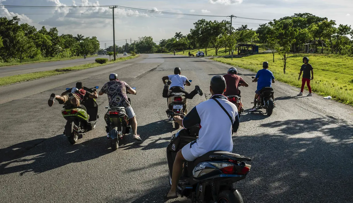 Orang-orang berlomba dengan skuter listrik mereka saat mereka berkumpul di sore hari untuk memamerkan aksi dan balapan di Havana, Kuba, pada 15 Juli 2022. Kuba telah dibanjiri dalam beberapa tahun terakhir dengan "motorinas", begitu skuter listrik ini disebut di pulau itu, sebuah mode bagi banyak orang, tetapi juga solusi untuk masalah transportasi dan kekurangan bahan bakar yang melanda negara Karibia itu. (AP Photo/Ramon Espinosa)