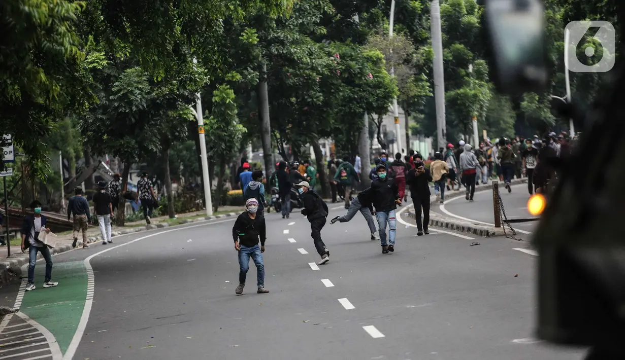 Pengunjuk rasa terlibat bentrok dengan aparat kepolisian di sekitar Patung Kuda, Jakarta Pusat, Selasa (13/10/2020). Unjuk rasa  menolak Omnibus Law Undang-Undang Cipta Kerja tersebut ricuh. (Liputan6.com/Faizal Fanani)