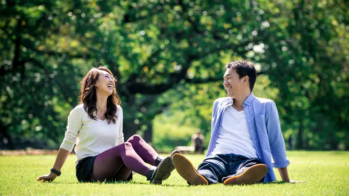 perempuan dan pasangan duduk piknik