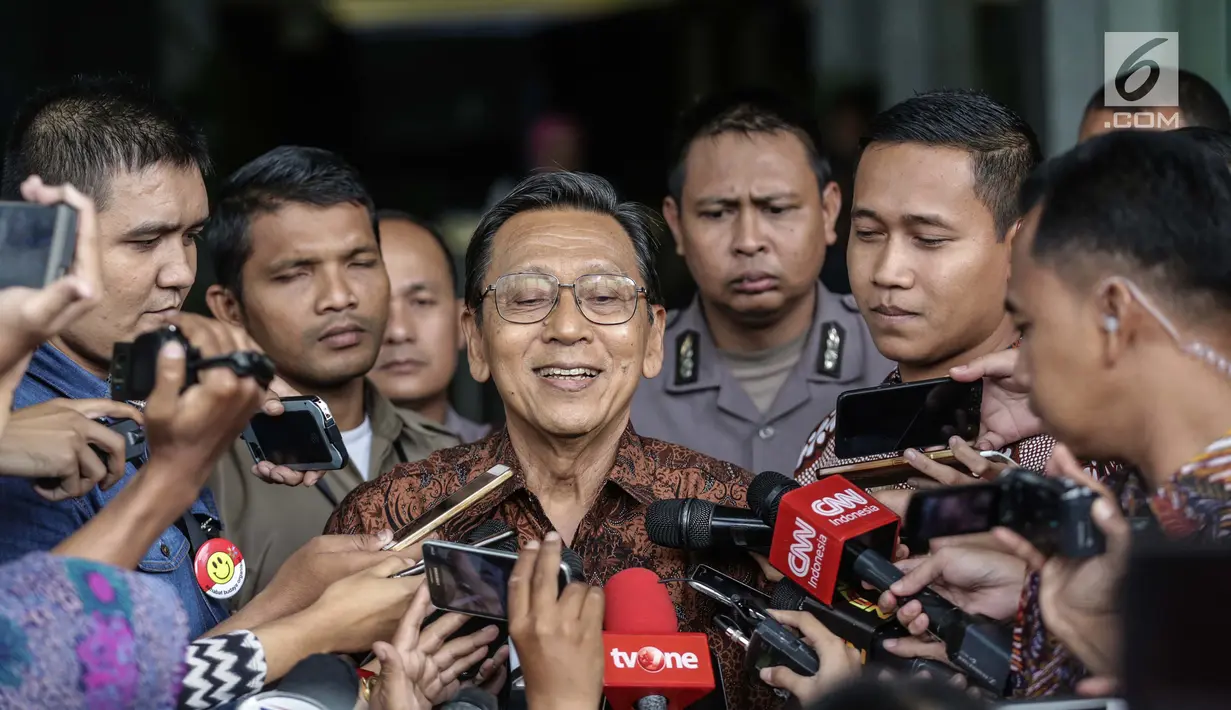Mantan Wakil presiden RI Boediono menjawab pertanyaan wartawan seusai diperiksa di gedung KPK, Jakarta, Kamis (28/12). Boediono mendatangi KPK atas inisiatifnya sendiri karena sebelumnya berhalangan hadir untuk diperiksa. (Liputan6.com/Faizal Fanani)