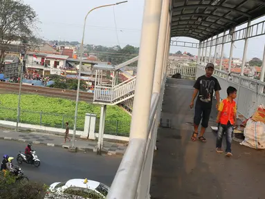 Pejalan kaki melintasi jembatan penyeberangan orang di Jakarta, Minggu (6/8). Dinas Bina Marga DKI Jakarta pada tahun ini akan merevitalisasi JPO yang sudah tua di Ibu Kota. (Liputan6.com/Immanuel Antonius)