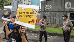 Massa yang tergabung dalam Walhi DKI Jakarta dan KRuHa menggelar aksi protes simbolik di depan Kedutaan Besar Inggris, Jakarta, Jumat (11/6/2021). Aksi yang bertepatan dengan pertemuan puncak G7 tersebut menolak utang baru untuk penanggulangan COVID-19. (Liputan6.com/Faizal Fanani)