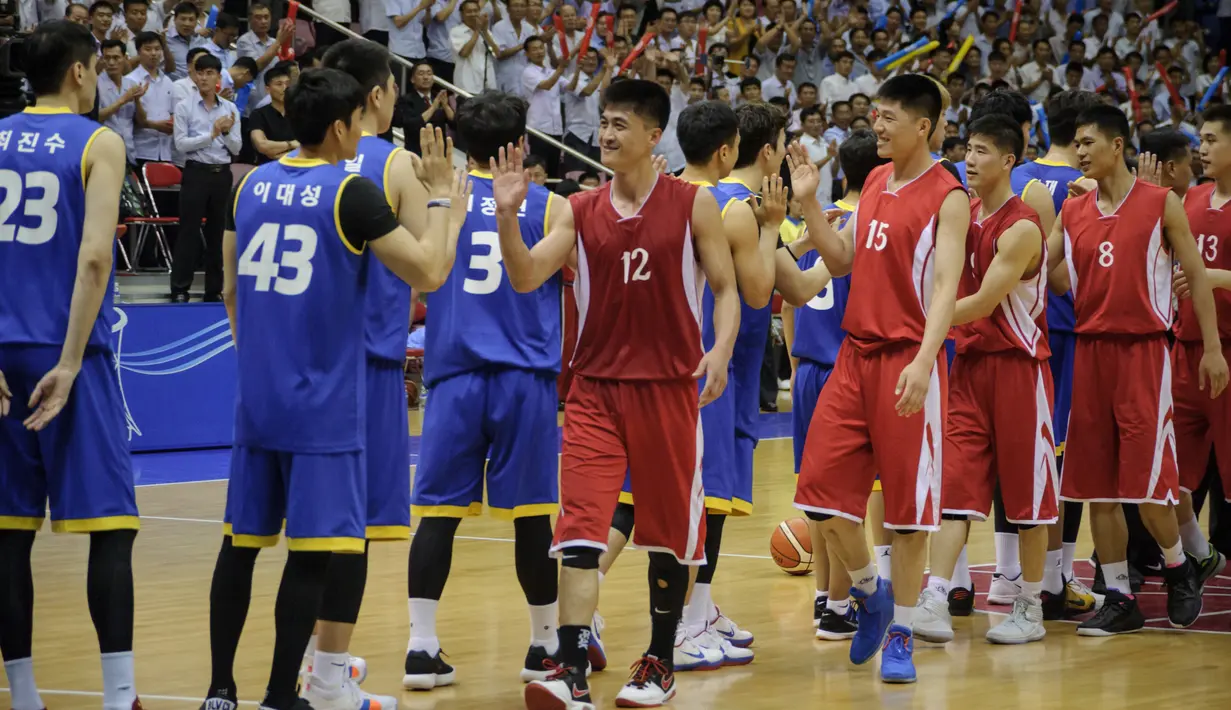 Pemain Korea Utara (merah) bersalaman dengan pemain Korea Selatan (biru) usai pertandingan basket pria di Stadion Indoor Ryugyong Chung Ju-Yung, Pyongyang (5/7). (AFP Photo/Kim Won-Jin)