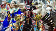Penari dari Navajo Nation, Ziggy Williams saat mengikuti Grand Entry of the Denver March Powwow di Denver, Colorado (24/3). Acara ini diikuti oleh sekitar 55.000 peserta, terdiri dari penari, penabuh, vendor, dan penonton. (AFP/Jason Connolly)