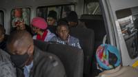 Penumpang, beberapa memakai masker, menunggu taksi mereka meninggalkan pangkalan taksi Baragwanath di Soweto, Kamis (2/12/2021). Afrika Selatan mempercepat kampanye vaksinasi untuk memerangi lonjakan pesat kasus Covid-19 usai mendeteksi varian Omicron pekan lalu. (AP Photo/Jerome Delay)