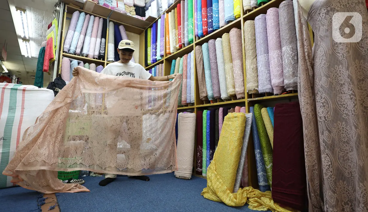 Pedagang menata kain bahan di Pasar Tanah Abang, Jakarta, Rabu (18/5/2022). Kementerian Perindustrian memproyeksikan industri tekstil dan produk tekstil (TPT) bakal tumbuh 3,5 persen pada semester I/2022. (Liputan6.com/Angga Yuniar)