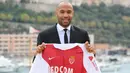 Legenda Prancis, Thierry Henry, memegang jersey saat diperkenalkan sebagai pelatih baru AS Monaco di Monaco, Rabu (17/10). Dirinya menggantikan posisi yang ditinggalkan Leonardo Jardim. (AFP/Valery Hache)
