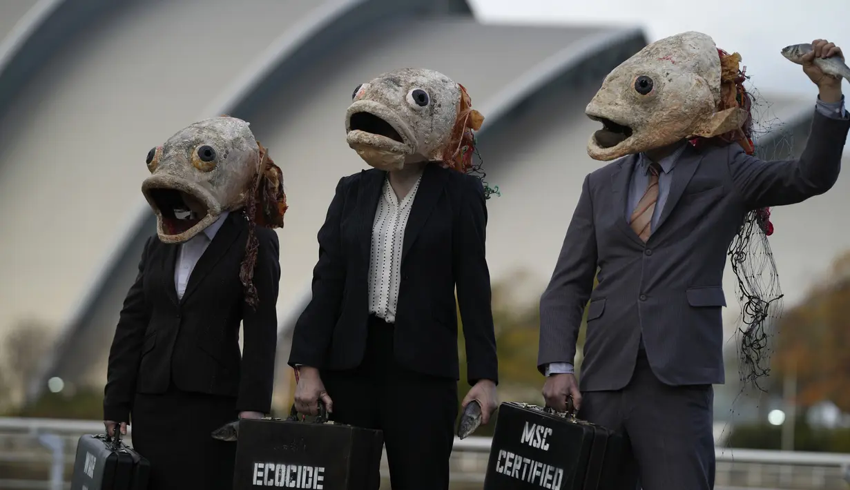 Juru kampanye dari kelompok lingkungan Ocean Rebellion mengenakan topeng kepala ikan saat aksi protes terhadap Marine Stewardship Council (MSC) di Glasgow, Skotlandia, 4 November 2021. Aksi ini dilakukan di sela-sela KTT Iklim PBB COP26 yang sedang berlangsung. (AP Photo/Alastair Grant)