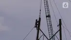Pekerja tengah melakukan aktivitas kerja pada ketinggian di menara sutet di kawasan Karang Tengah, Kota Tangerang, Banten, Jumat (8/1/2021). Keselamatan dan kesehatan kerja (K3) merupakan hal yang mutlak bagi para pekerja di ketinggian dengan risiko tinggi. (Liputan6.com/Angga Yuniar)